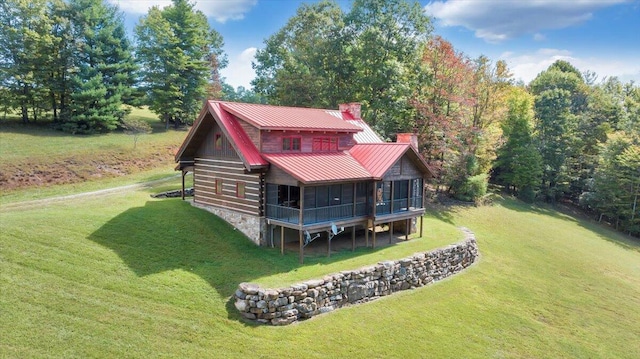 rear view of house with a yard and a sunroom