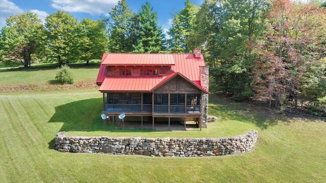 back of property with a lawn and a sunroom