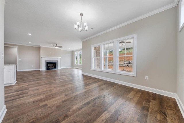 unfurnished living room with crown molding, dark wood-type flooring, and a notable chandelier