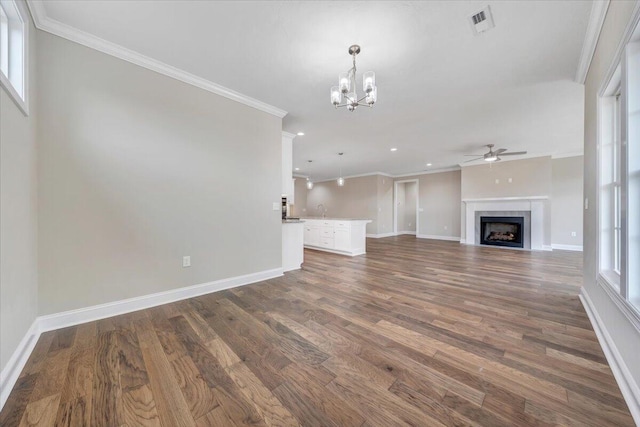 unfurnished living room with dark hardwood / wood-style flooring, a healthy amount of sunlight, and ornamental molding