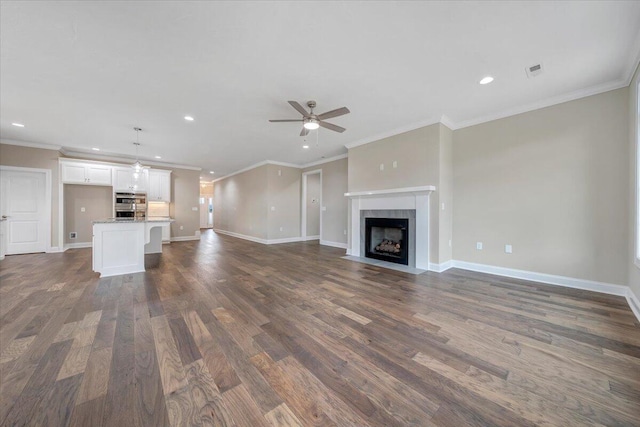 unfurnished living room with dark hardwood / wood-style floors, ceiling fan, ornamental molding, and a fireplace