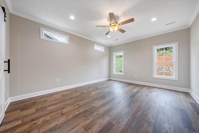 unfurnished room featuring a barn door, dark hardwood / wood-style floors, ceiling fan, and ornamental molding