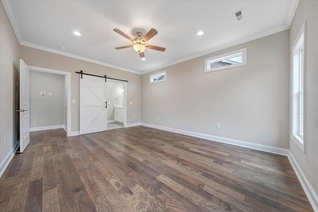 unfurnished bedroom featuring a barn door, ceiling fan, crown molding, and dark wood-type flooring