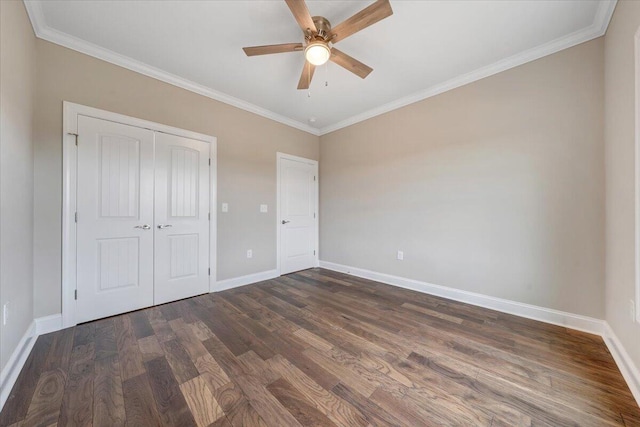 unfurnished bedroom featuring ornamental molding, a closet, ceiling fan, and dark wood-type flooring