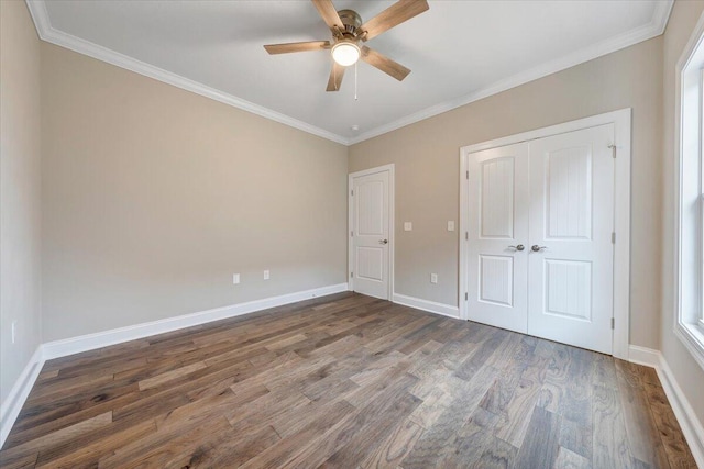 unfurnished bedroom featuring a closet, ceiling fan, dark hardwood / wood-style flooring, and crown molding