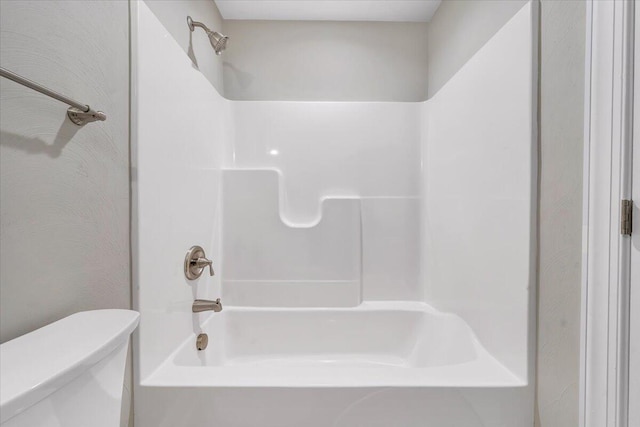 bathroom featuring toilet and bathtub / shower combination