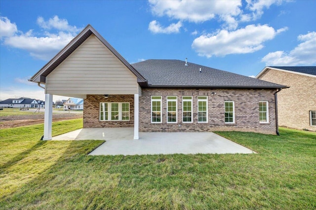 back of property featuring a patio area and a lawn