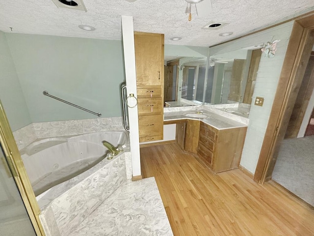 53 Woodberry Ln, Galax, VA 24333 - full bath featuring a textured ceiling, wood finished floors, vanity, and a whirlpool tub
