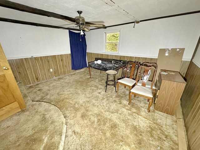 living area with carpet, wooden walls, and ceiling fan