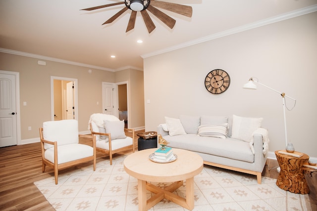 living room featuring ornamental molding, light wood-type flooring, and ceiling fan