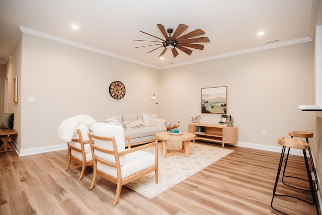 living room with ornamental molding, light hardwood / wood-style floors, and ceiling fan