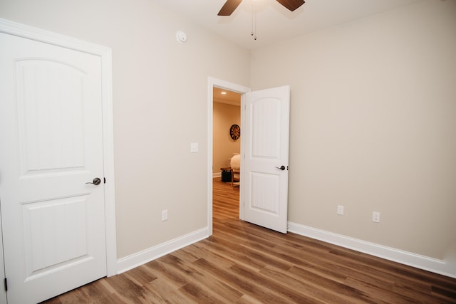 unfurnished bedroom with ceiling fan and hardwood / wood-style flooring