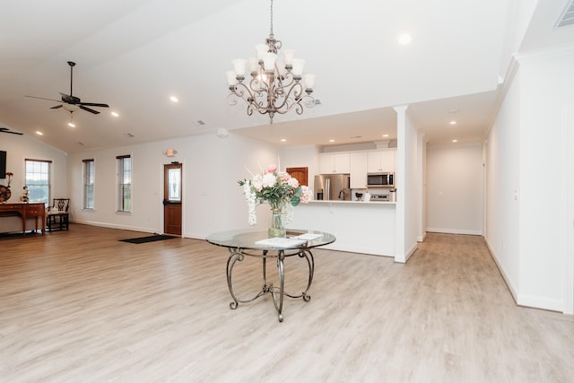 interior space featuring ornamental molding, ceiling fan with notable chandelier, light hardwood / wood-style floors, and lofted ceiling