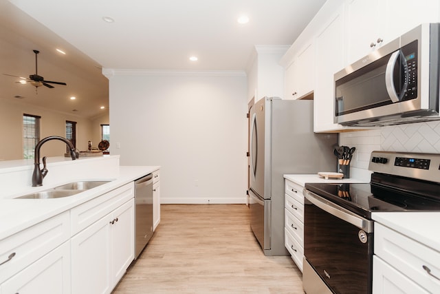 kitchen with white cabinets, stainless steel appliances, ceiling fan, light hardwood / wood-style flooring, and sink