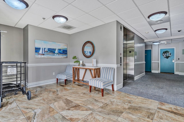 living area featuring a paneled ceiling