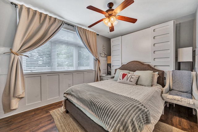 bedroom with dark hardwood / wood-style flooring and ceiling fan