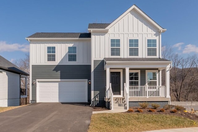 view of front of property with a garage, a front yard, and a porch