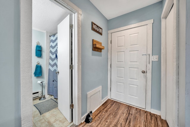 interior space with hardwood / wood-style floors and a baseboard heating unit