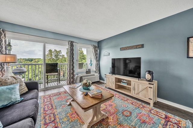 living room with a textured ceiling and dark wood-type flooring