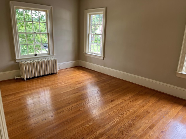 spare room with light hardwood / wood-style floors and radiator heating unit