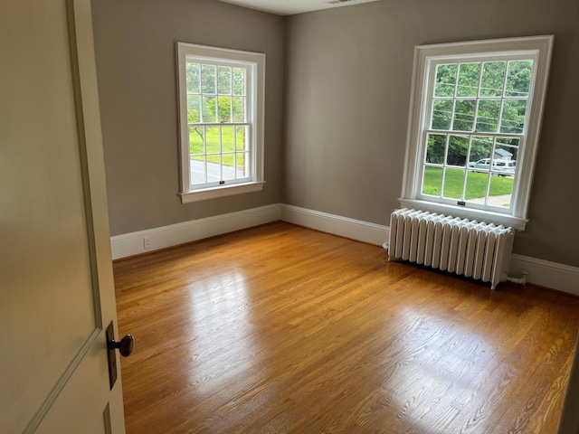 spare room with radiator and light hardwood / wood-style floors