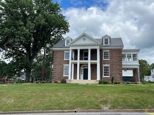 neoclassical / greek revival house with a balcony and a front lawn