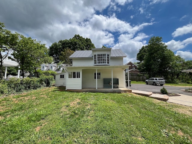 rear view of house featuring a lawn