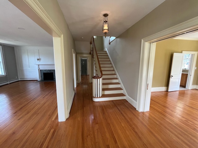 staircase with hardwood / wood-style flooring and a premium fireplace