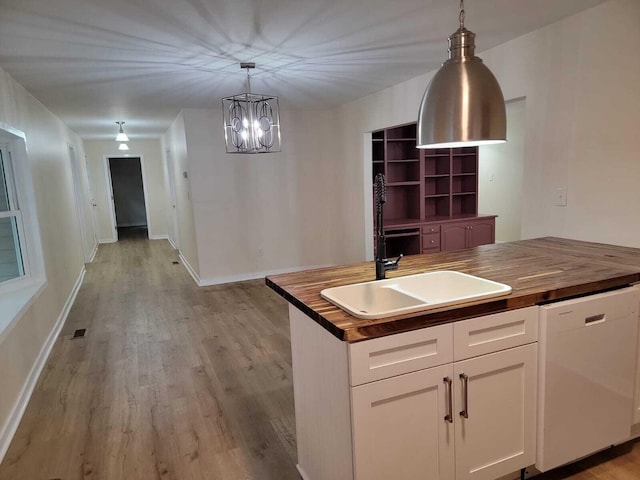 kitchen with white cabinets, dishwasher, hanging light fixtures, and wooden counters