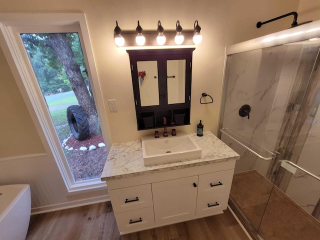 bathroom with vanity, shower with separate bathtub, and hardwood / wood-style floors