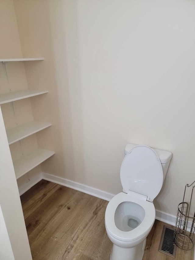 bathroom with wood-type flooring and toilet