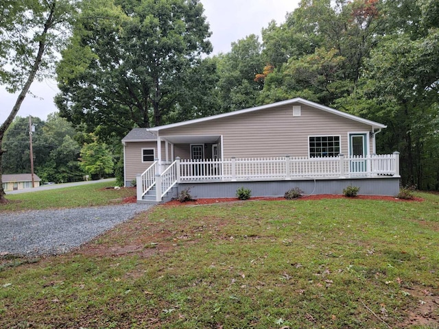 view of front of property featuring a deck and a front lawn