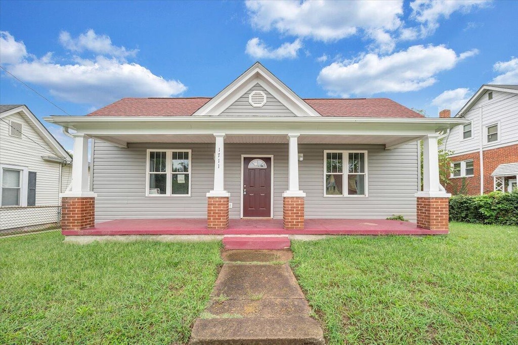 view of front of house featuring covered porch and a front yard