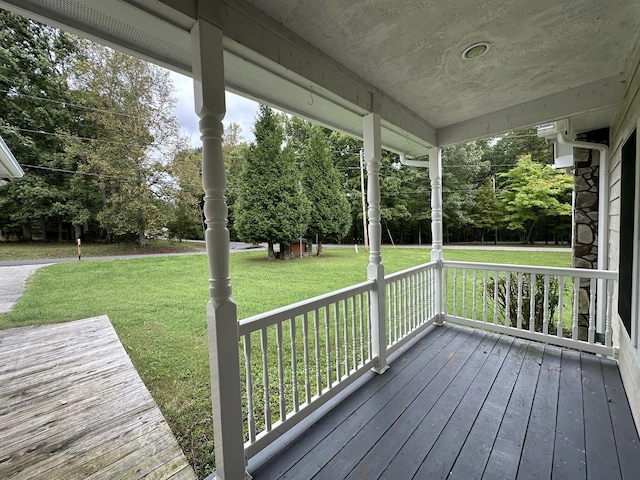 wooden deck featuring a lawn