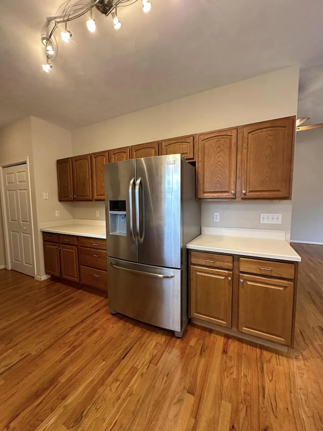 kitchen with stainless steel refrigerator with ice dispenser and wood-type flooring