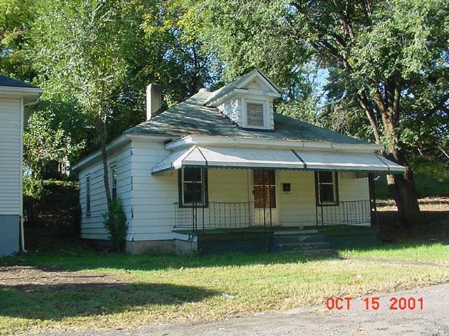 view of front of property with a porch and a front lawn