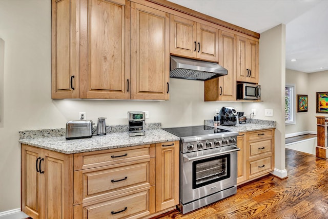 kitchen with dark wood-type flooring, light stone counters, stainless steel appliances, and ventilation hood