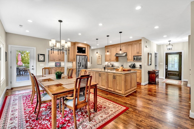 dining area with a chandelier, sink, and dark hardwood / wood-style flooring