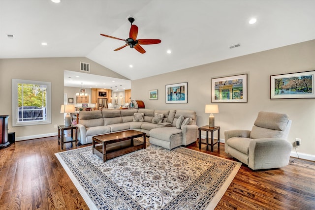 living room with vaulted ceiling, ceiling fan with notable chandelier, and dark hardwood / wood-style flooring