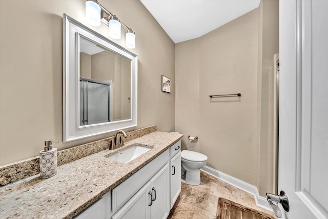 bathroom with a shower with door, vanity, and toilet