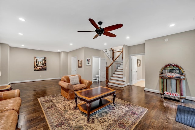 living room featuring dark wood-type flooring and ceiling fan