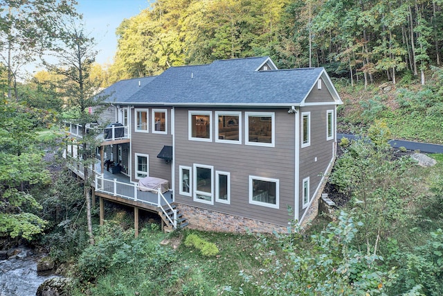 rear view of property featuring a wooden deck