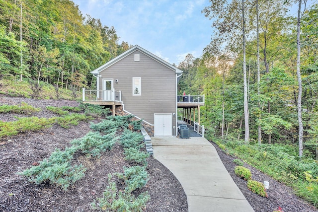 rear view of property with central AC and a wooden deck