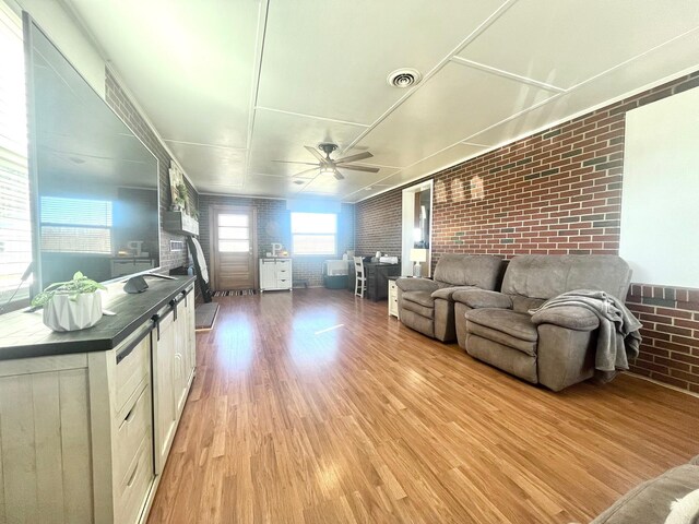 kitchen featuring light stone counters, stainless steel appliances, sink, pendant lighting, and light hardwood / wood-style flooring