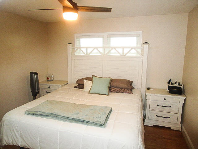 bedroom with ceiling fan and dark hardwood / wood-style floors