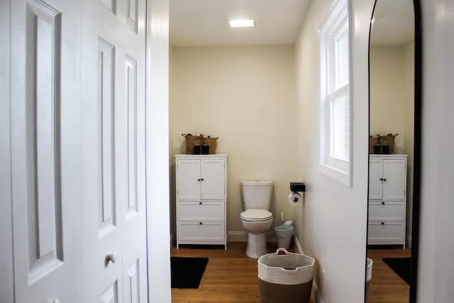 bathroom with toilet and hardwood / wood-style flooring