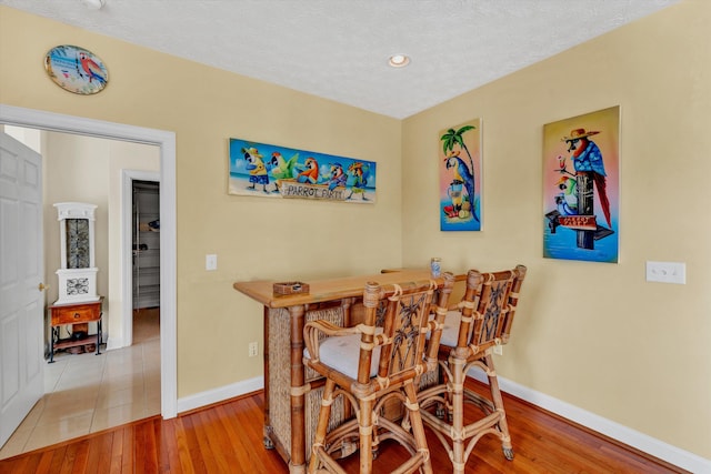 dining space with a textured ceiling and wood-type flooring