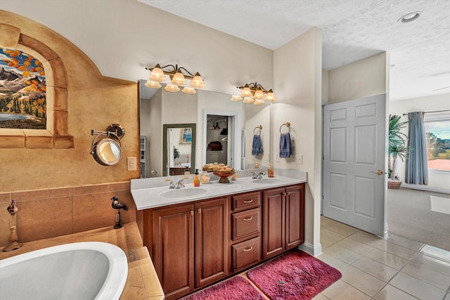 bathroom with vanity, a textured ceiling, a washtub, and tile patterned floors