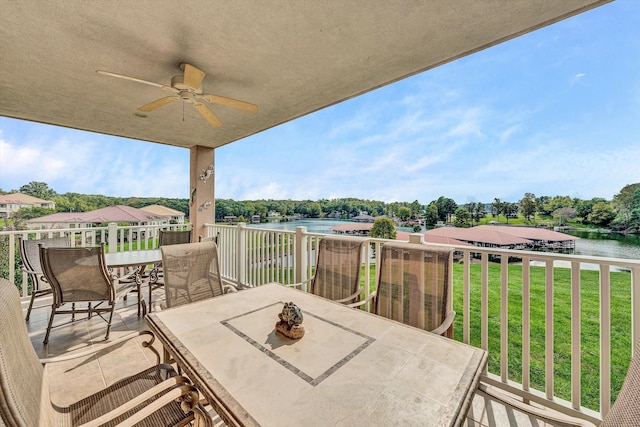 wooden terrace featuring a water view, ceiling fan, and a yard