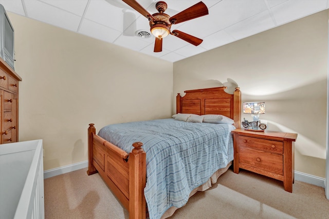 carpeted bedroom with a drop ceiling and ceiling fan